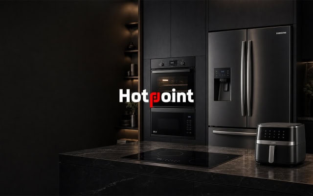 Hotpoint promotional image showing black kitchen appliances in a dark modern kitchen