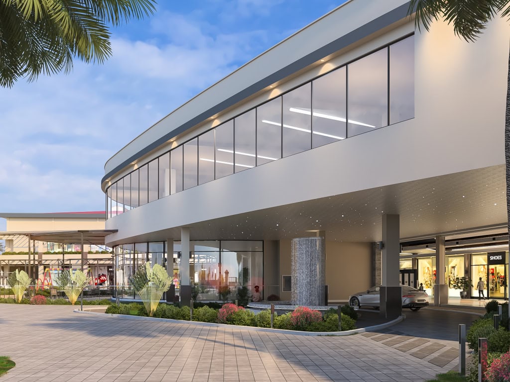 Curved glass-fronted shopping mall building with landscaped entrance