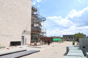 Scaffolding, construction materials, and workers beside a large building