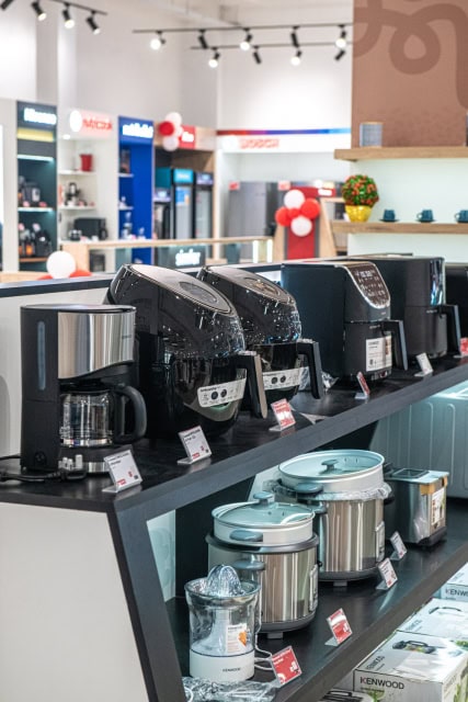 Coffee makers, kettles and stainless steel cookware displayed on retail shelves