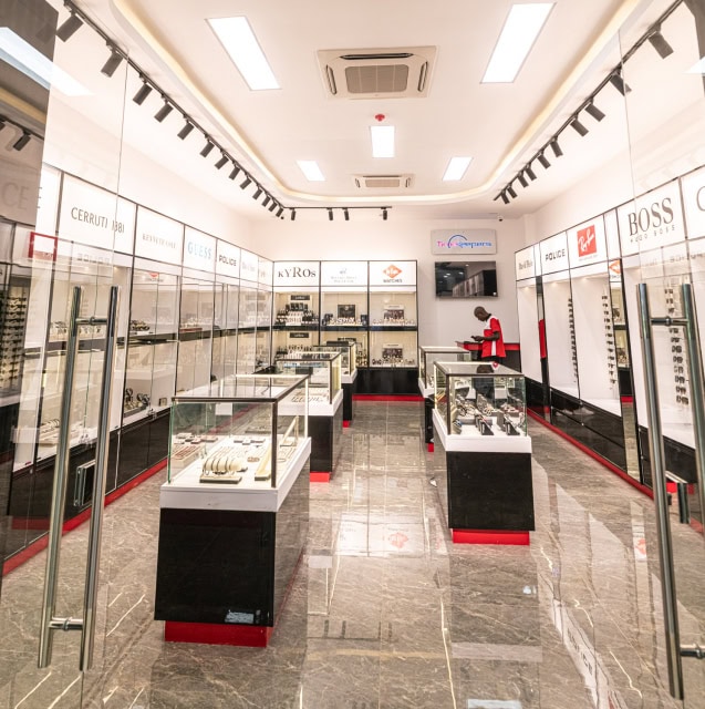 Wide view of a watch store interior with glass display cabinets and central showcases.