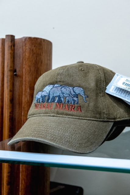 Olive baseball cap with an embroidered animal graphic and lettering