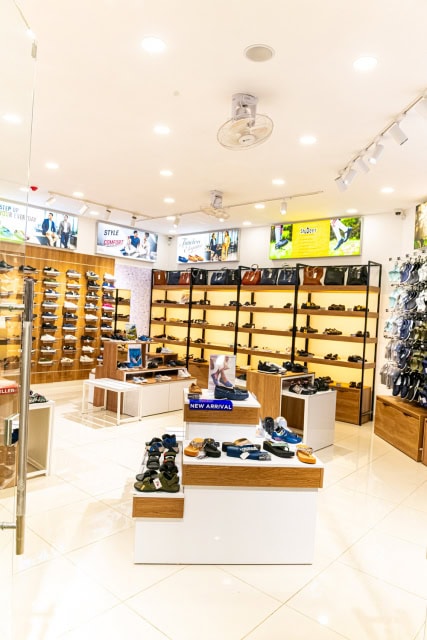 Bright UMOJA store interior with shoes arranged on wall shelves and display tables