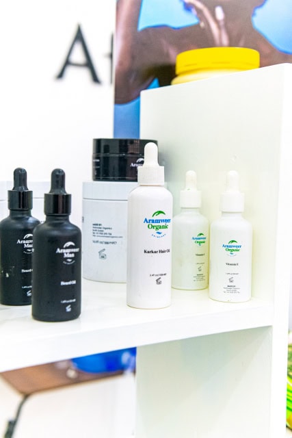 Aramweer Organic skincare bottles and containers arranged on a white shelf.