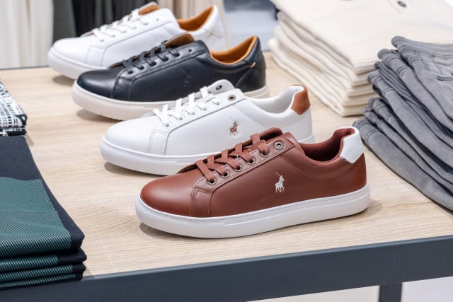 White, black and brown low-top sneakers arranged on a store display table