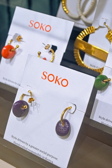 Gold-tone earrings with colorful round pendants displayed on SOKO cards.