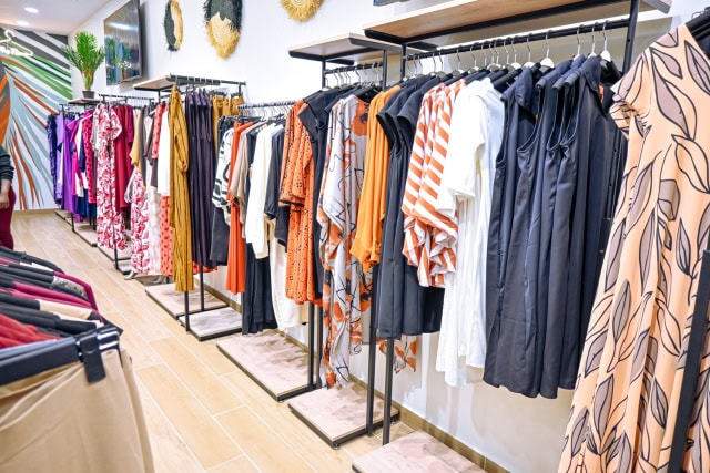 Wide view of clothing racks displaying colourful garments inside a fashion store