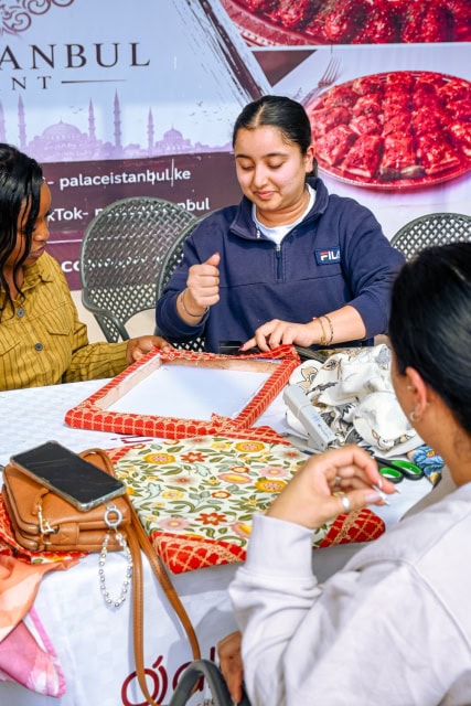 Participant works on a fabric-covered frame during the Frame and Fabric Workshop at Galleria Shopping Mall.
