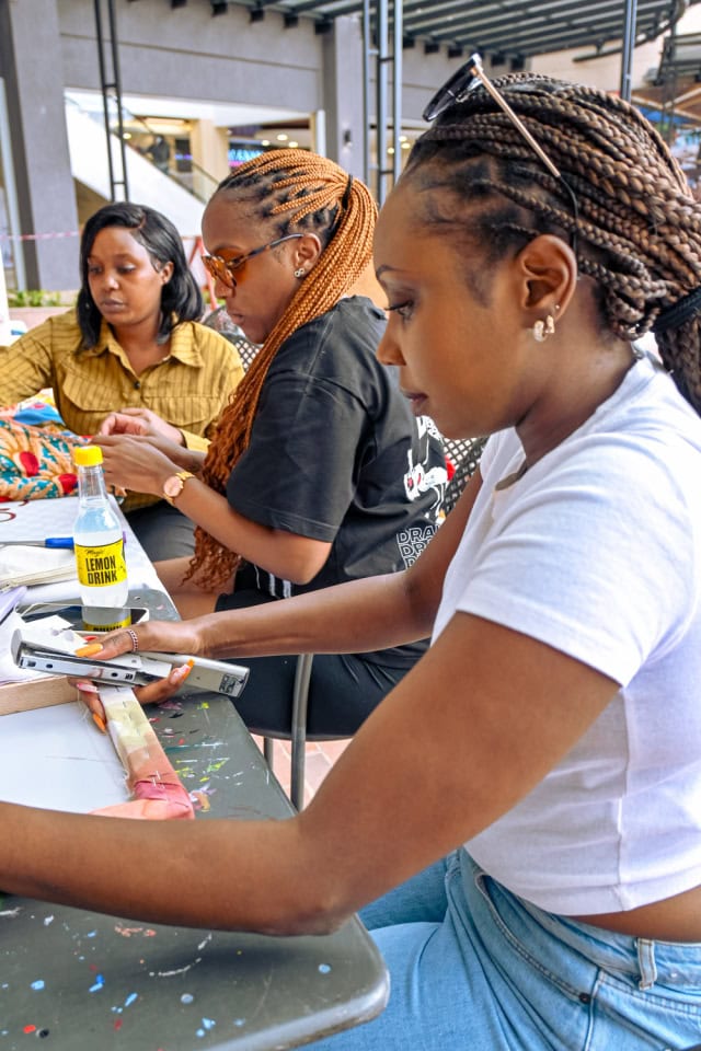 Three participants work together on fabric projects during the Frame and Fabric Workshop at Galleria.