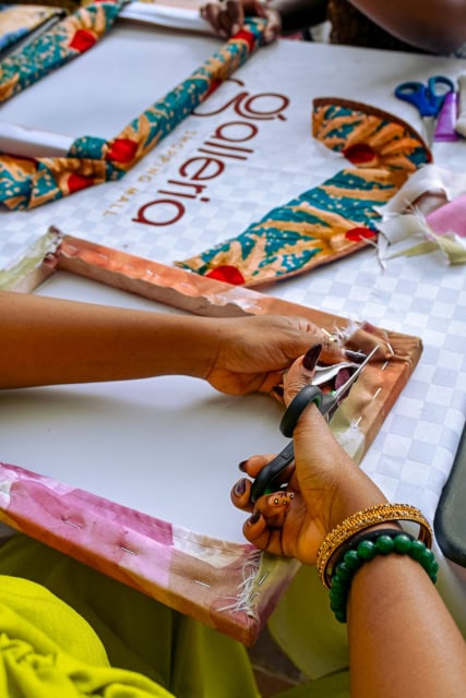 Close-up of a participant cutting patterned fabric during the Frame & Fabric Workshop at Galleria