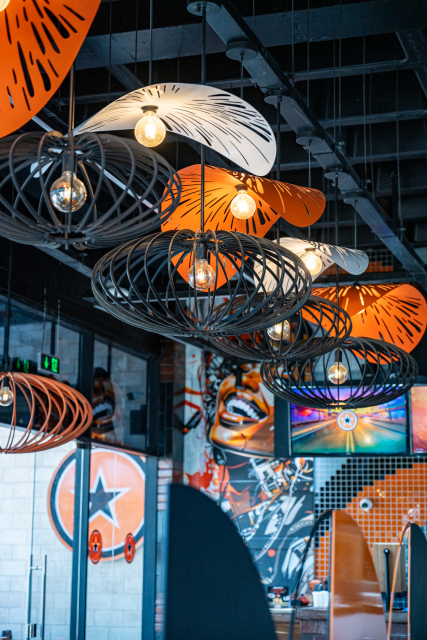 Interior view with black wire pendant lights and orange leaf-shaped shades