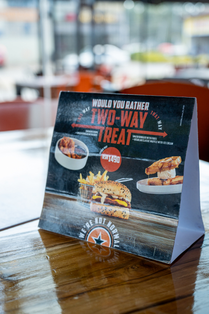 Tabletop promotional card showing food items and prices for two-way treats