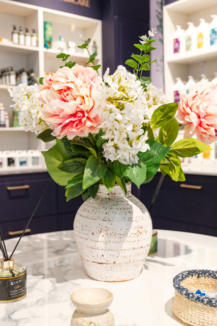 Floral arrangement in a ceramic vase on a retail display table