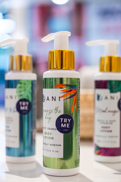 Green JANI body lotion bottle with a Try Me label displayed among other bottles