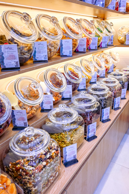 Shelves lined with glass jars of assorted bulk foods and labeled product cards