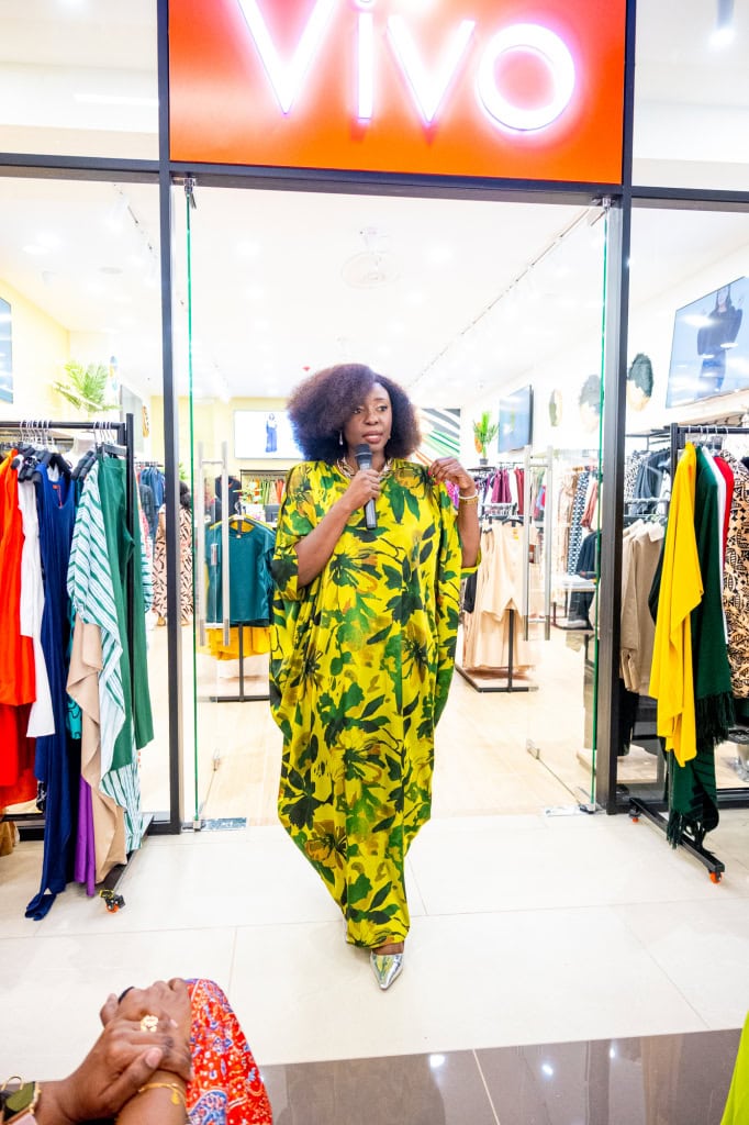 Connie Oluoch stands beneath the Vivo sign at the entrance to the Style, Shop & Sip event.