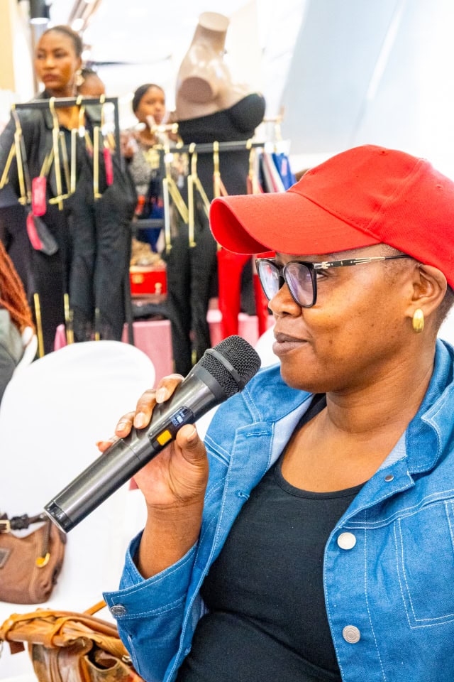 A guest in a red cap speaks into a microphone during Style, Shop & Sip with Connie Oluoch.