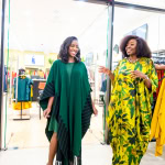 Connie Oluoch and a guest smile and talk beside clothing displays during Style, Shop & Sip at Galleria Shopping Mall.