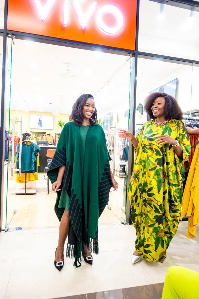 Connie Oluoch and a guest smile and talk beside clothing displays during Style, Shop & Sip at Galleria Shopping Mall.