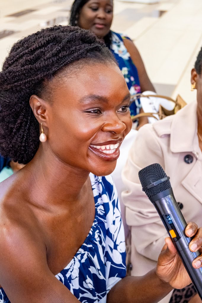 A smiling guest speaks into a microphone during the Style, Shop & Sip event