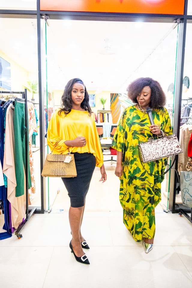 Two women model colourful outfits and handbags as they walk through the store during Style, Shop & Sip.