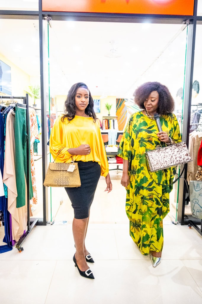 Two women model colourful outfits and handbags as they walk through the store during Style, Shop & Sip.
