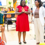 A smiling guest applauds beside the host during Style, Shop & Sip at Galleria Shopping Mall