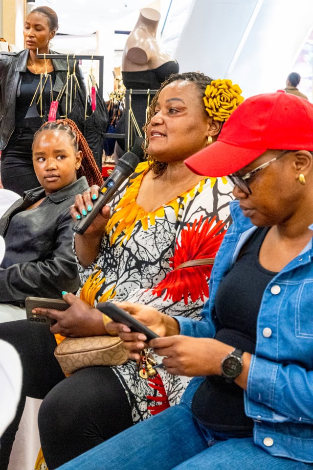 A guest speaks into a microphone during the Style, Shop & Sip event at Galleria Shopping Mall