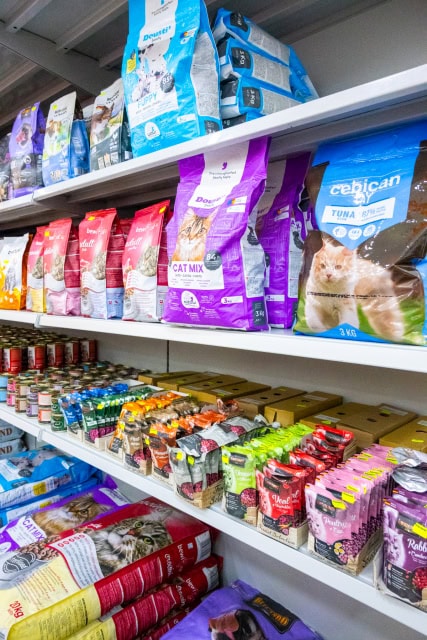Shelves stocked with assorted cat food bags, cans and pouches