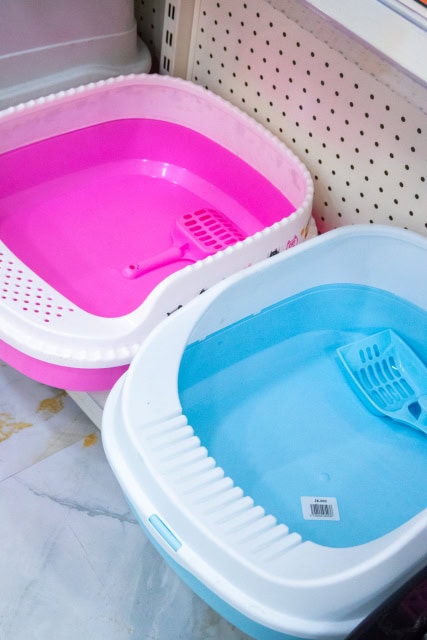 Pink and blue plastic pet litter trays with matching scoops