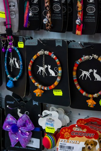 Display of colorful pet collars, accessories, bows, and toys.