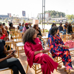 Guests Gather on the Outdoor Event Terrace Guests sit in rows of chairs on an outdoor terrace during a Galleria Shopping Mall event.