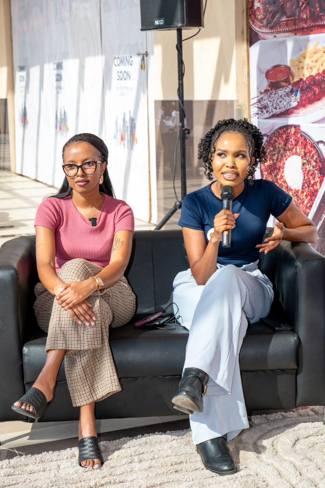 Women participating in a wellness discussion Two women sit on a lounge sofa during a wellness discussion, with one holding a microphone