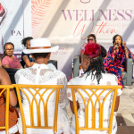Audience Listening to Wellness Discussion An audience seated on yellow chairs listens to two speakers during a Wellness Within discussion.