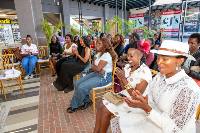An audience applauds and smiles while seated at the Wellness Within event inside the mall.