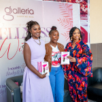 Guests holding wellness materials Three women pose with printed wellness materials in front of a Galleria Wellness backdrop