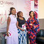 Three women pose at the Wellness Within backdrop Three smiling women pose together in front of a Wellness Within backdrop at Galleria Shopping Mall.