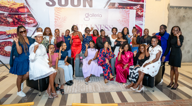 A large group of women pose together in front of a Galleria Wellness event backdrop.