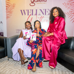 Guests Pose at the Wellness Event Backdrop Three women smile for a photo on a sofa in front of a Galleria Wellness event backdrop.