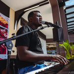 Musician Singing and Playing Keyboard Musician singing into a microphone while playing a keyboard.