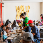 A busy group of participants making pottery together around tables