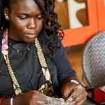 Participant concentrates while shaping clay by hand at a pottery table