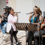 Two singers and three musicians performing together in a live band