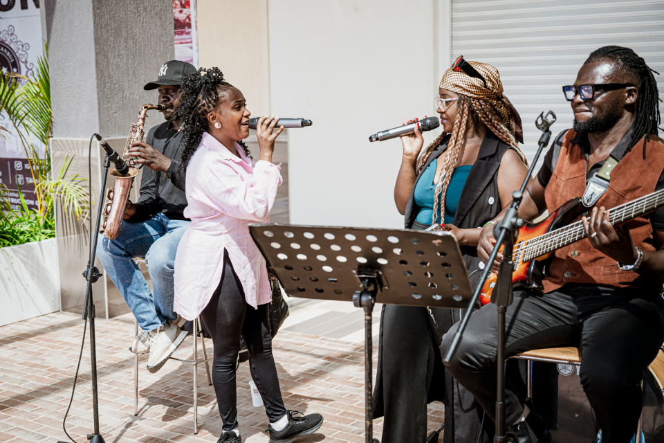 Two singers and three musicians performing together in a live band