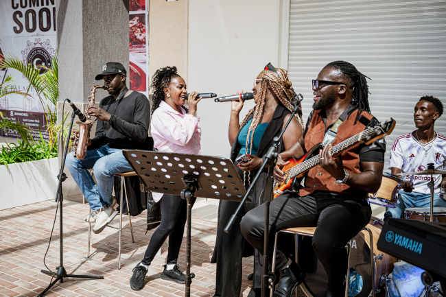 A full band performs together in a shopping mall concourse.