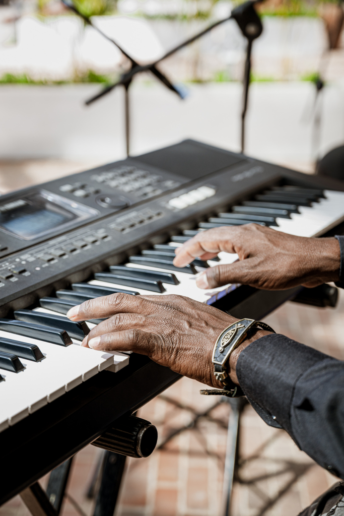 Close-up of a musician's hands playing an electronic keyboard.