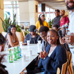 Attendees sit around a table with bottles and branded cups inside the shopping mall