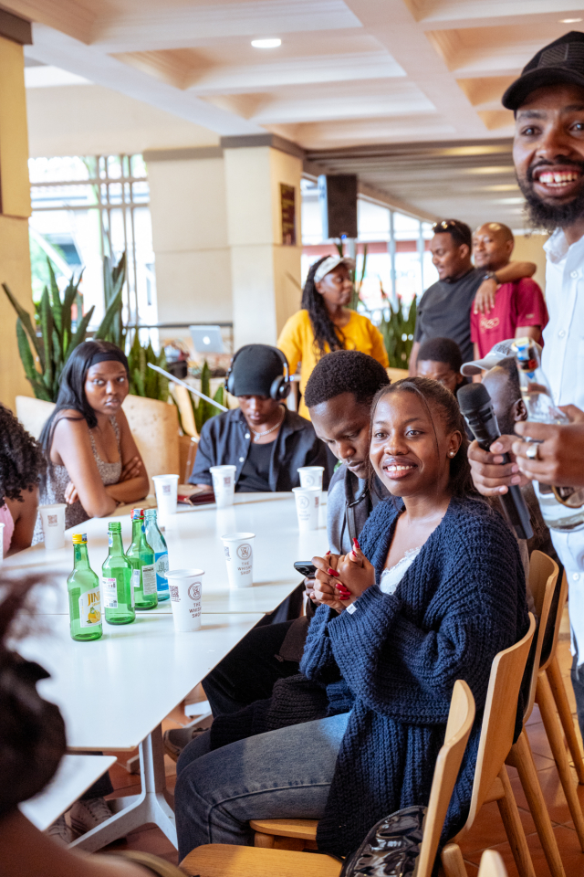 Attendees sit around a table with bottles and branded cups inside the shopping mall