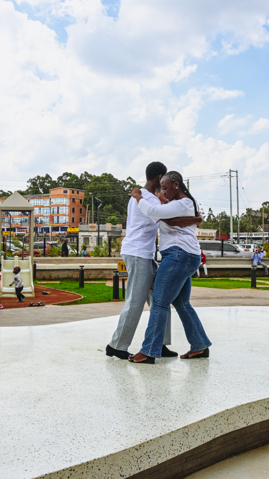 Couple Dancing Across the Plaza Two people dance closely together across an outdoor mall plaza