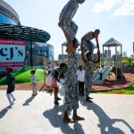 DZ6 1284 Performers form a human pyramid near a playground outside the shopping mall.